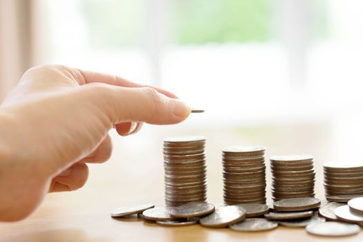 Saving money concept,Male hand putting money coin stack growing business