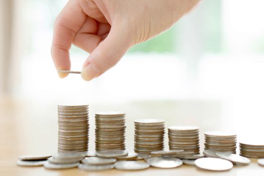 woman put coins to stack of coins