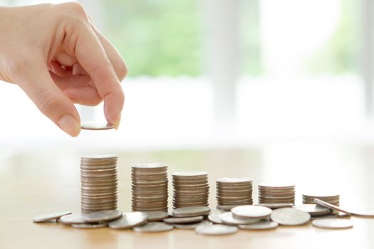 woman put coins to stack of coins