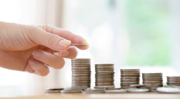 woman put coins to stack of coins