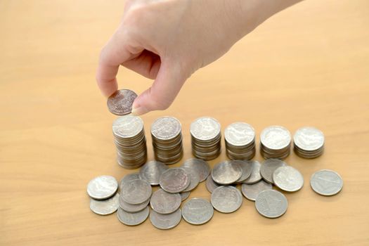 woman put coins to stack of coins