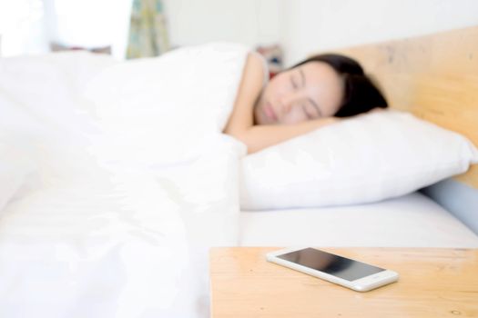 Sleeping Woman Being Woken By Mobile Phone In Bedroom