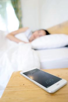 Sleeping Woman Being Woken By Mobile Phone In Bedroom