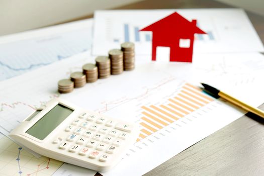  With House Model And Stack Of Coins On Desk