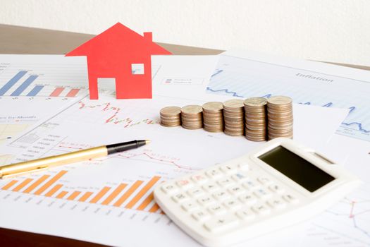  With House Model And Stack Of Coins On Desk