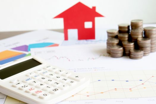  With House Model And Stack Of Coins On Desk