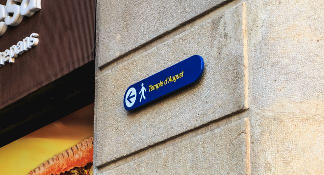 BARCELONA, SPAIN -  June 20, 2017 : small blue sign on a stone wall that indicates the direction for August Temple pedestrians on a summer day