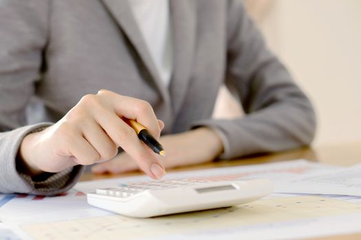 Close up of female accountant or banker making calculations. Savings, finances and economy concept