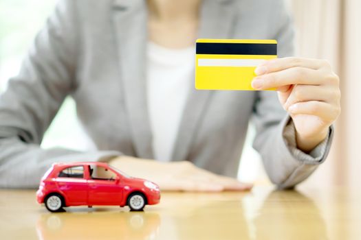Real estate investment by credit card. Car on table.