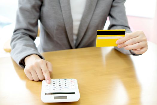 Businesswoman using a calculator to calculate his payment on credit card