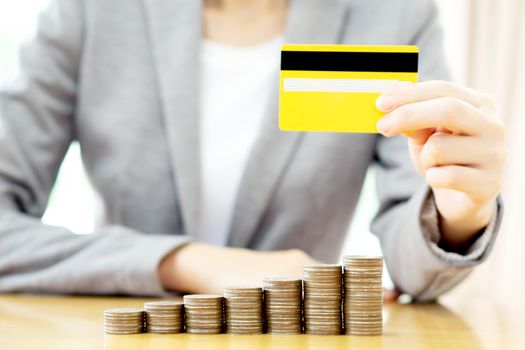 Businesswomen hand with credit card and  many coins in column 