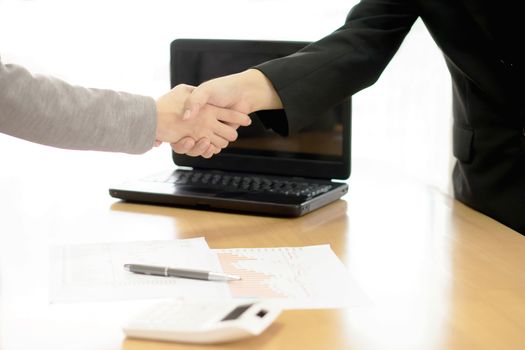 Two Businesspeople shaking hands indoors