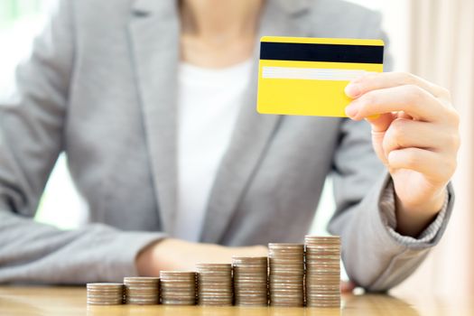 Businesswomen hand with credit card and  many coins in column 