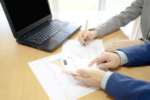 Two business colleagues working on a laptop computer in an office