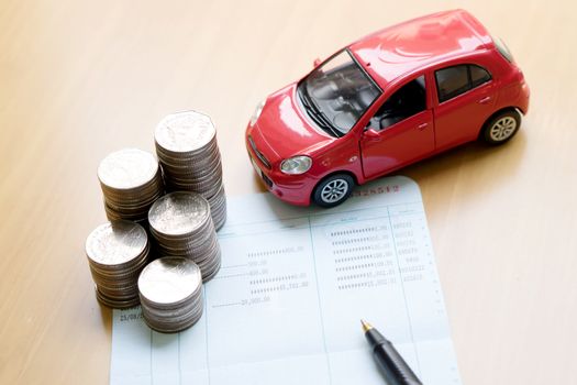 Rows of coins, account book, car. Finance and banking concept.