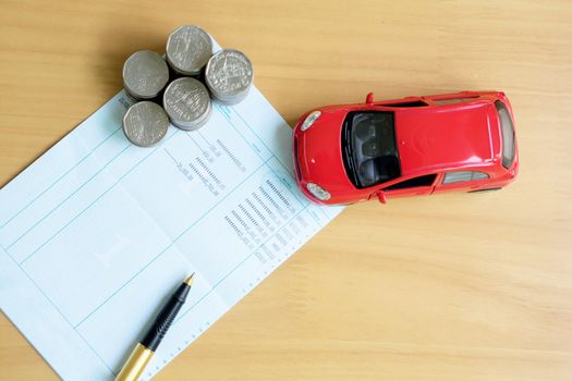 Rows of coins, account book, car. Finance and banking concept.