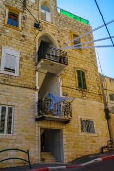 HAIFA, ISRAEL - OCTOBER 27, 2017: Historical houses in mixed Arab and International (Bauhaus) style, with locals and visitors, in Haifa, Israel