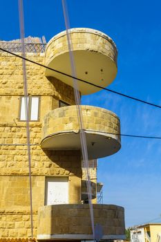 HAIFA, ISRAEL - OCTOBER 27, 2017: Historical houses in mixed Arab and International (Bauhaus) style, with locals and visitors, in Haifa, Israel