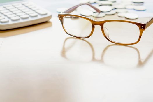 Glasses coin calculator on table