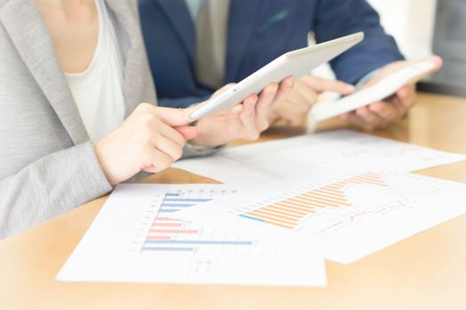 Business people discussing and analyzing market data information on a modern digital tablet compute