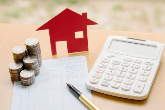 Coins stack in columns with saving book and paper home,concept