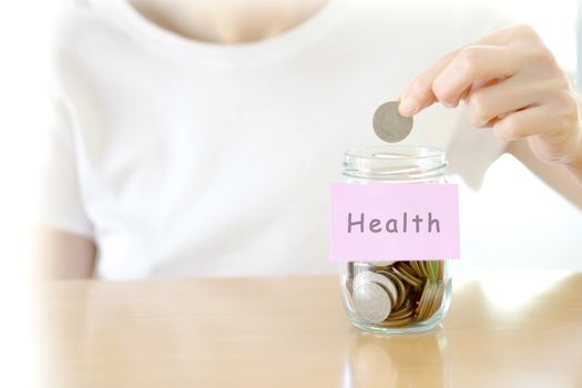 Woman hands with coins in glass jar, close up