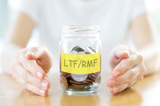 Woman holding money jar with coins close up