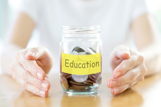 Woman holding money jar with coins close up