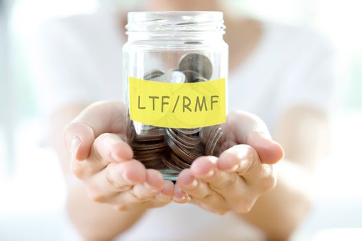 Woman holding money jar with coins close up 