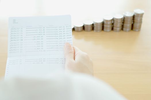 Woman hold book bank on hand, coins background