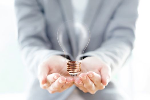 Businesswoman hold Light Bulb with soil 