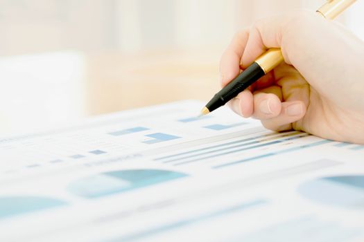 Businesswoman holding a pen and analyze data