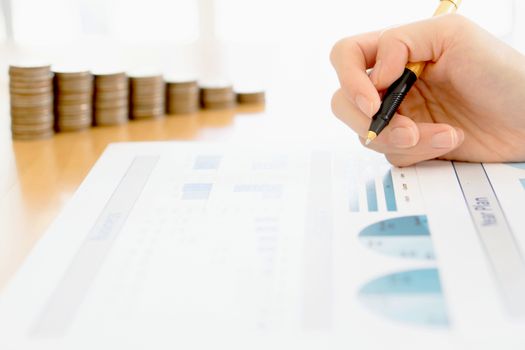 Businesswoman Analyzing Financial Graph With Coins 