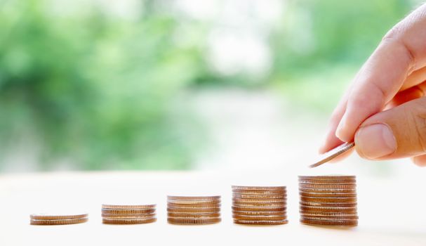 hand put money coins to stack of coins. Money, Financial, Business Growth concept.