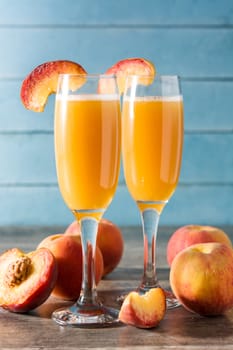 Bellini champagne cocktail in crystal glass on blue wooden table