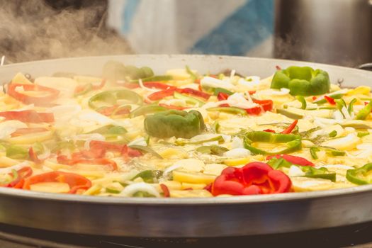 street vendor boils vegetables in a large pot in Spain