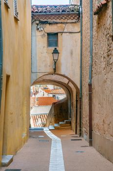 View of a little narrow street with an arch in the town of Brignoles in Provence, south of France