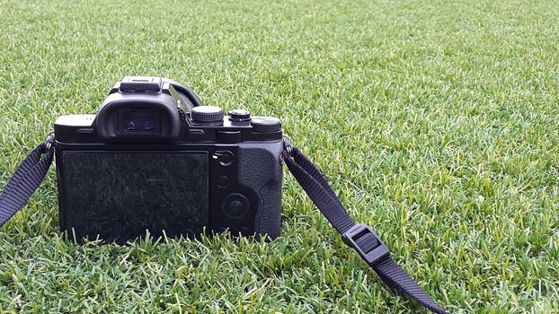 Digital photo camera on grass in summer. 