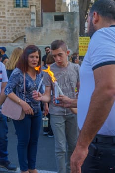 Haifa, Israel - April 27, 2019: Holy fired being shared by locals, in Orthodox Easter celebration in Haifa, Israel. Traditionally fire is ignited on Holy Saturday in the church of the Holy Sepulchre