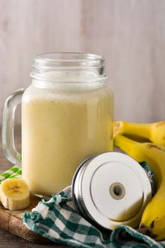 Banana smoothie in jar on wooden table