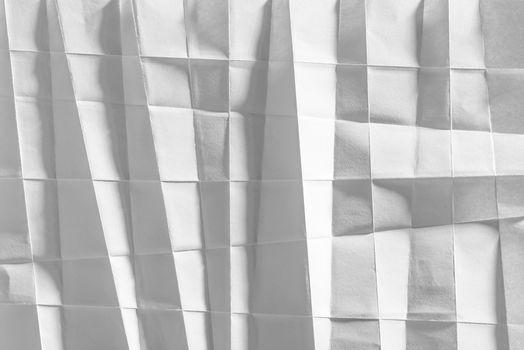 White folded sheet of paper showing an abstract texture design under the light grazing. Good to use as background