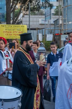 Haifa, Israel - April 27, 2019: Priest carrying the holy fire, during a Holy Saturday parade, part of Orthodox Easter celebration in Haifa, Israel