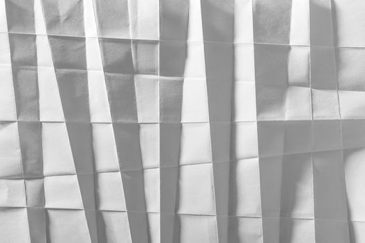 White folded sheet of paper showing an abstract texture design under the light grazing. Good to use as background