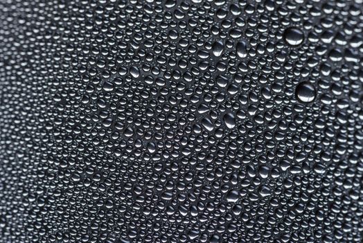 Many little water drops due to condensation on a plastic bottle curved surface