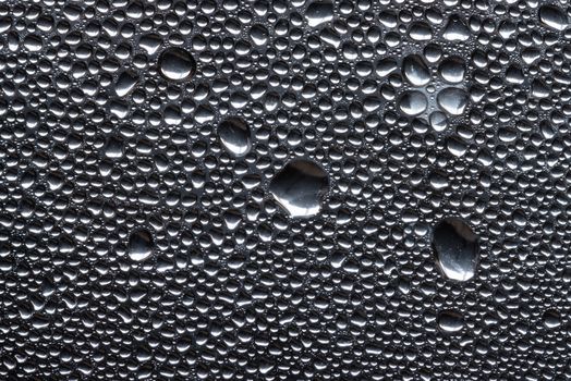 Many little water drops due to condensation on a plastic bottle curved surface