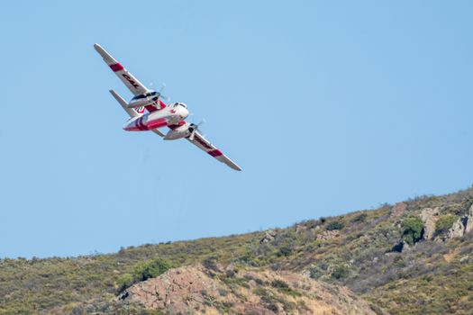 Winchester, CA USA - June 14, 2020: Cal Fire aircraft preparingto drop fire retardant on a dry hilltop wildfire near Winchester, California.