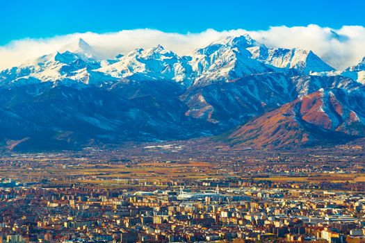 Cityscape of Turin with picturesque snowy Alps high rising on the background, Italy