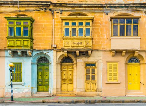 Malta, Valletta: Facade of a residential house with traditional maltese balconies. House made of yellow bricks in the street of Malta.