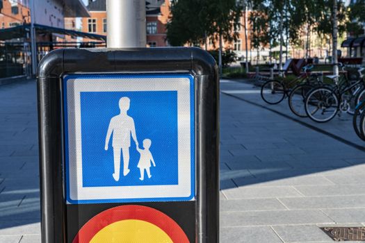 Pedestrian traffic sign - men with child in a blue square, keep hand while crossing street, Europe, Sweden