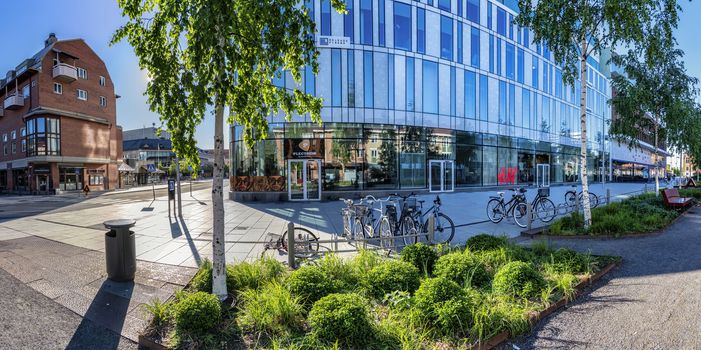 UMEA, SWEDEN - JUNE 10, 2020: Scenic view of downtown - nice mixture of modern and old buildings. Early sunny summer day, no people, bright colors of modern architecture and birches, Vasterbotten